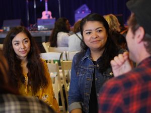 Two people sitting in a circle listening to others speak.