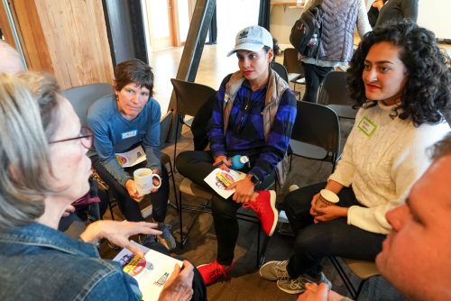 A small group sitting in a circle listening to one another speak.