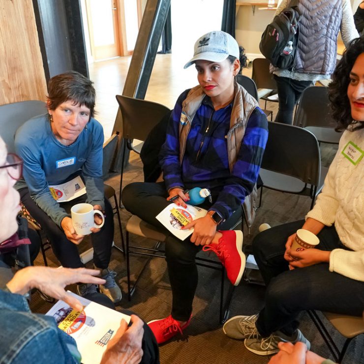 A small group sitting in a circle listening to one another speak.
