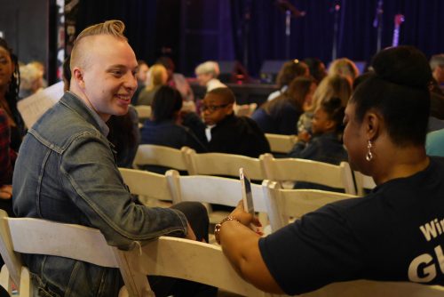 Two people talking and smiling while seated.