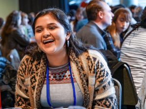 A person sitting in a group and smiling.