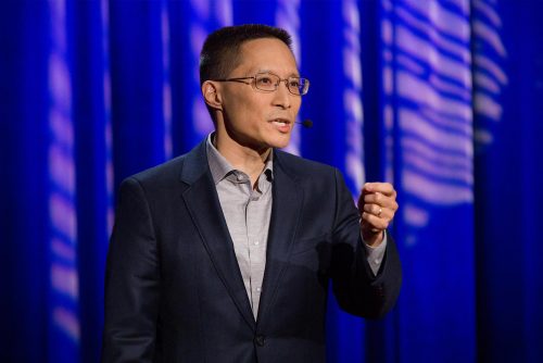 Eric Liu speaking to a crowd from a stage with a Civic Saturday podium.