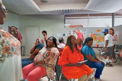 A group of people sitting in a room together talking and laughing.