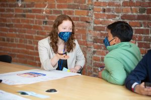 A candid image of YC alumna, Ellie Friedman speaking with a fellow YC member.