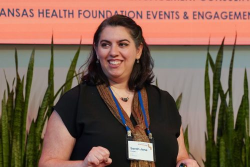 A photo of Sarah Jane speaking on a stage.