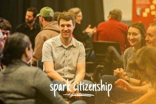 People sitting in a small group chatting together, with the text, spark citizenship.