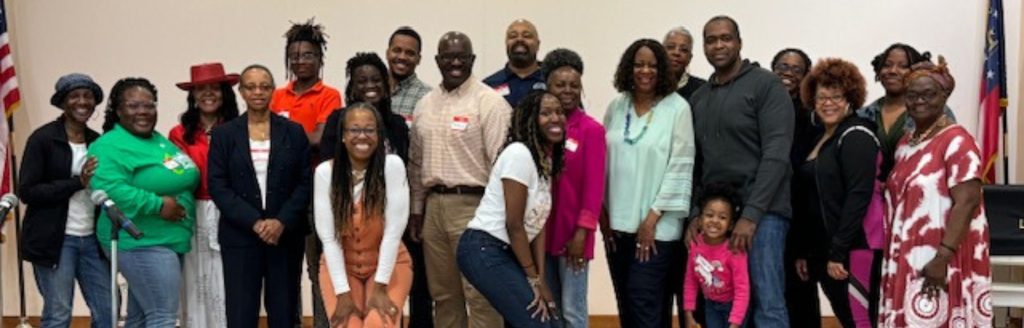 A group of people smiling and standing together on a stage 