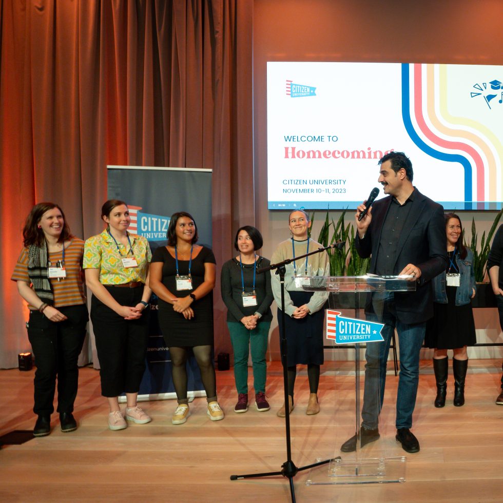 The CU team standing at the front of a room.