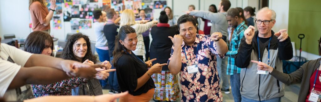 People smiling and pointing to one another.