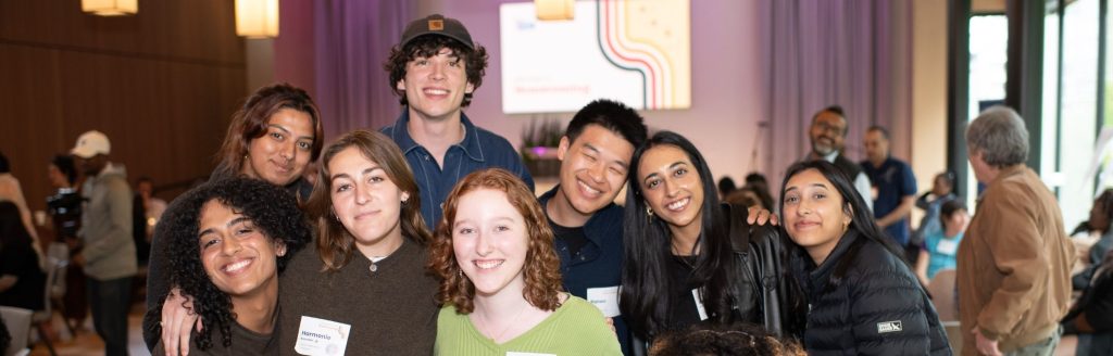 A group of young people standing and smiling together.