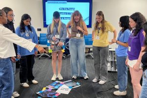 A group of students standing together and working on a project